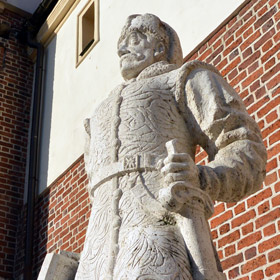 pomnik króla Stefana Batorego na tle południowej ściany zamku